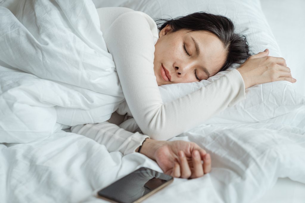 Imagen de una mujer que sabe que dormir apropiadamente es bueno para su piel.