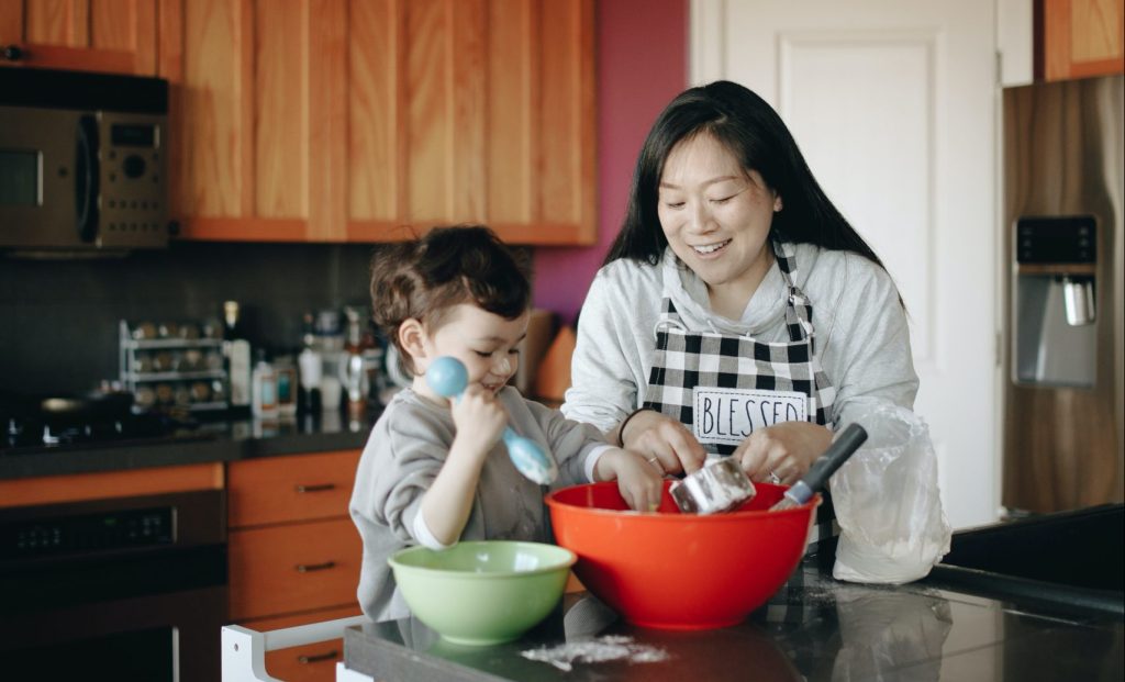 Imagen de una madre cocinando unas recetas saludables junto a su hijo.