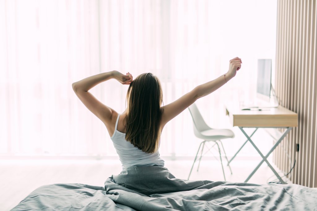 Imagen de una chica despertándose. 5 hábitos para tener energía todo el día.